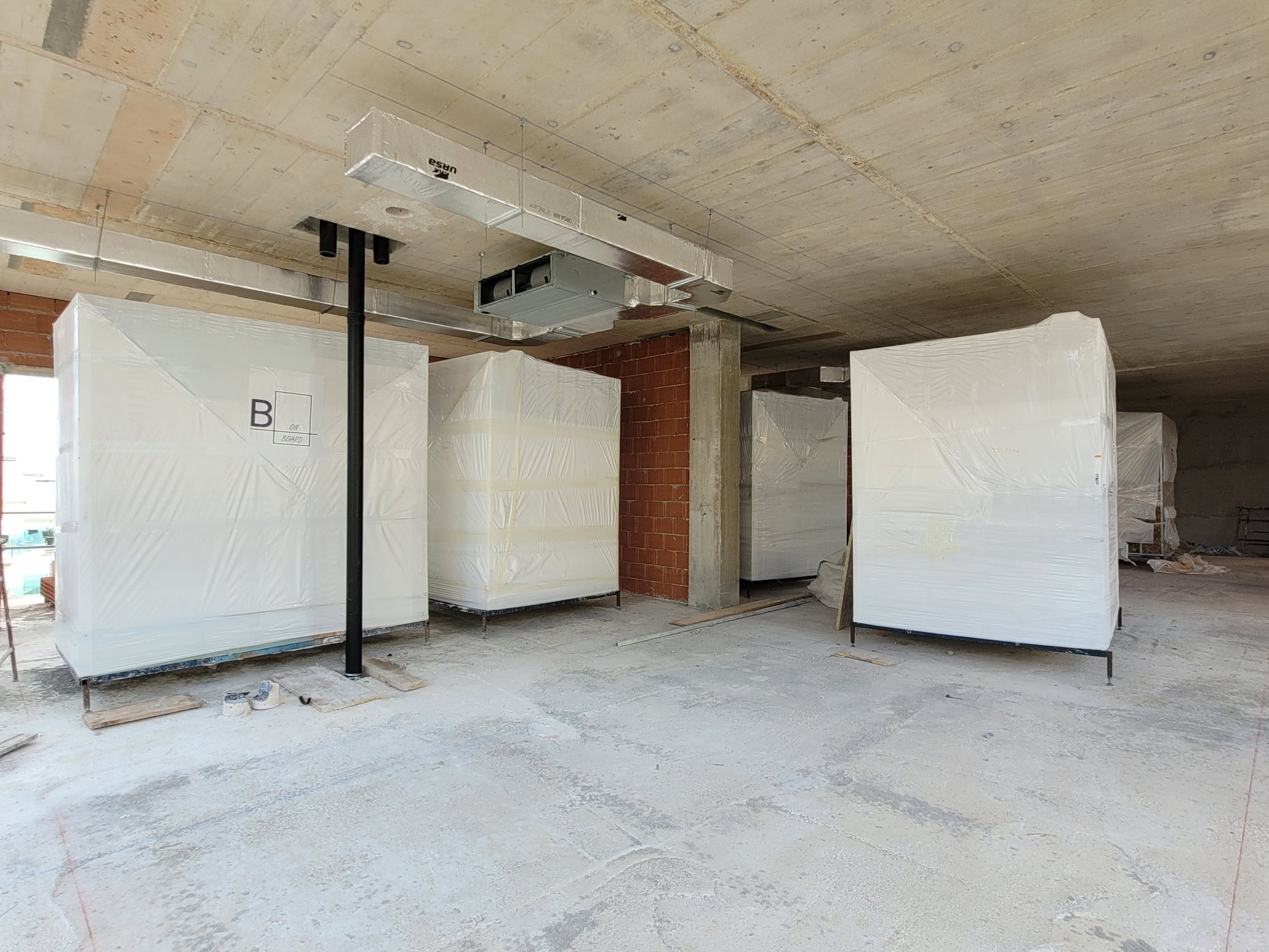 Baños industrializados ya colocados en su posición bajo el forjado de una planta en obra