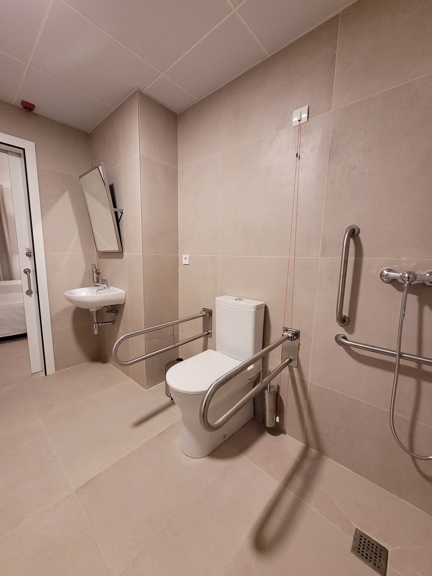 Barras de apoyo abatibles junto al inodoro de un baño accesible terminado