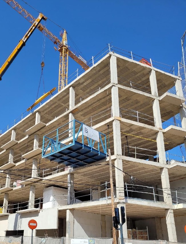 Plataforma de descarga de Bath on Board izada con la grúa de obra hasta el forjado receptor de un edificio en estructura
