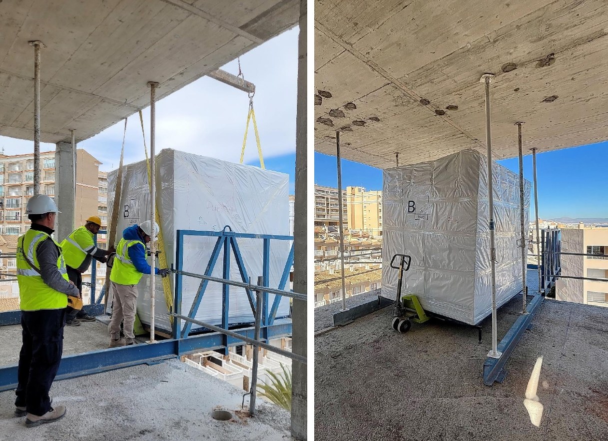 Técnicos de montaje recibiendo una cabina de baño industrializada embalada en la plataforma de descarga y, a la derecha, la cabina ya sobre el forjado con la transpaleta